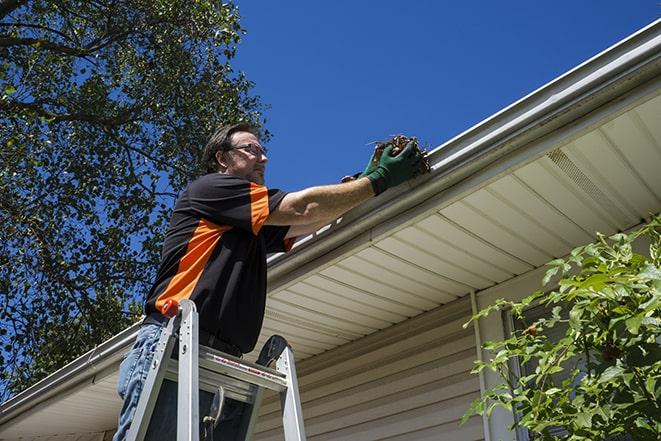 a repairman working on a broken gutter system in Amlin, OH